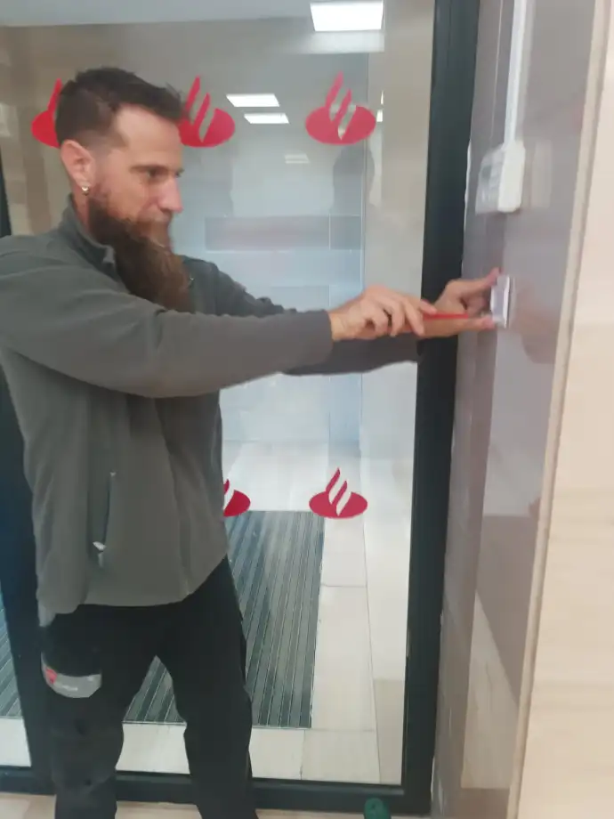 Alarmas de seguridad Aingenia Trabajador de Aingenia instalando alarma en Banco Santander