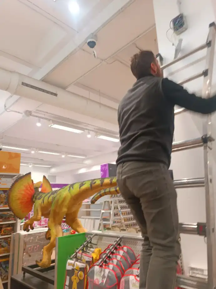 Instalación de CCTV Aingenia Trabajador de Aingenia en Toys´r us subiendo una escalera