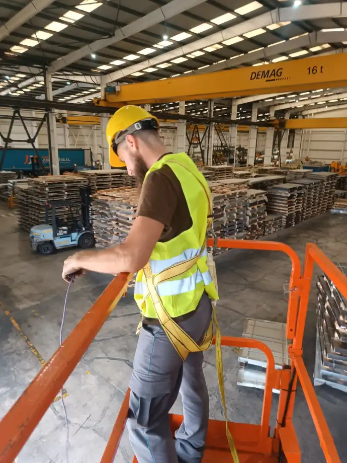 Instalaciones eléctricas de baja tensión Aingenia Trabajador de Aingenia manipulando un cable en un almacén